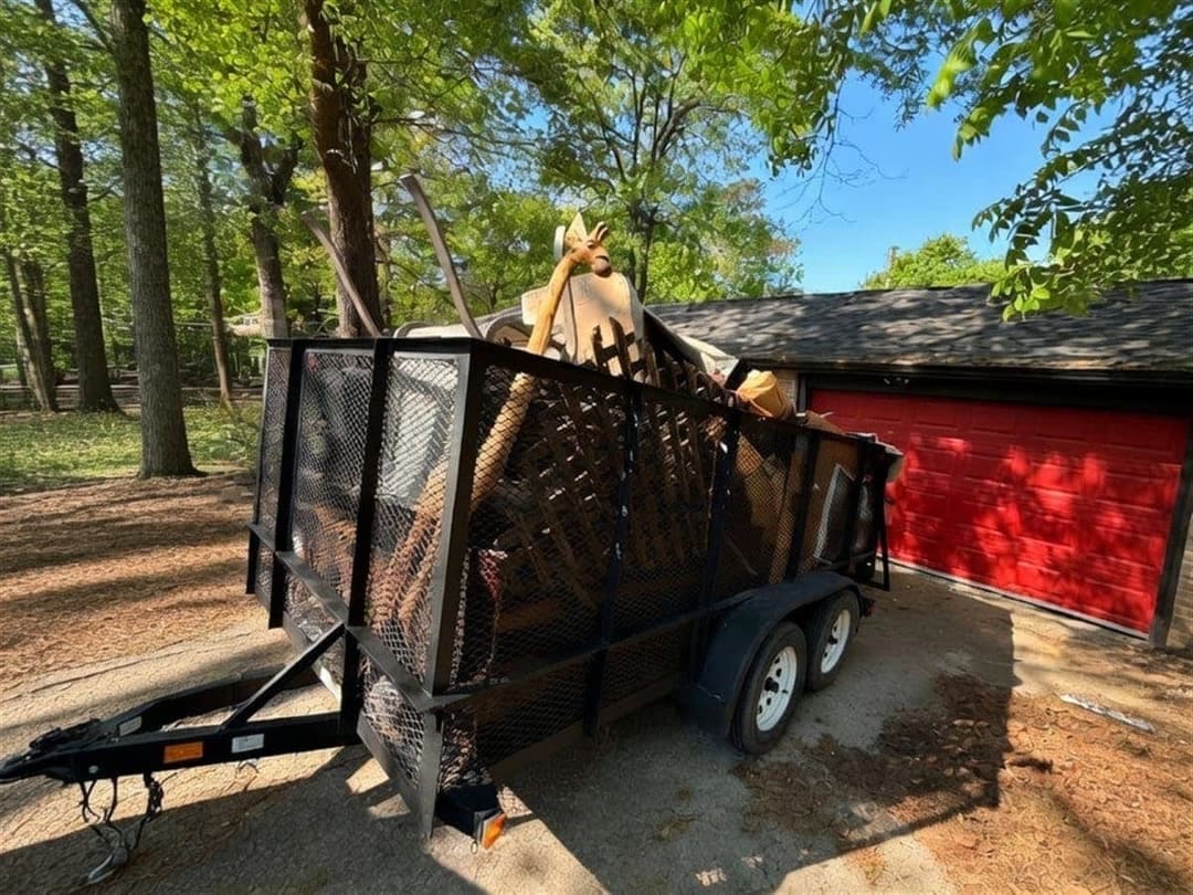 Equipo de ANSEB Junk Removal cargando un tráiler lleno de muebles, electrodomésticos y escombros en Houston